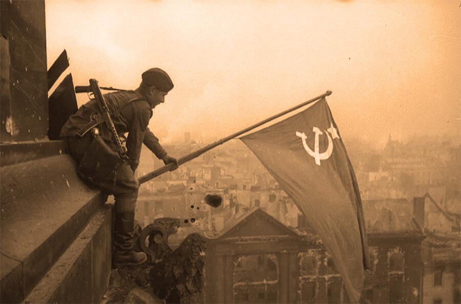 Боец РККА водружает первый советский флаг над Рейхстагом